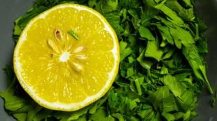 Розрізаний навпіл чудодійний лимон та зелень